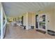 Expansive covered porch with rocking chairs, tiled floor, and views of the yard at 5108 Waterwood Dr, Bartow, FL 33830