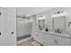 Modern bathroom with double vanities, sleek black fixtures, and a walk-in shower with glass surround at 5458 Oakford Dr, Lakeland, FL 33812