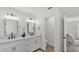 Stylish bathroom featuring double sinks, modern faucets, and a door leading to the adjacent bedroom at 5458 Oakford Dr, Lakeland, FL 33812