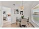 Cozy dining nook with views to the bedroom, highlighted by a unique woven pendant light and backyard access at 5458 Oakford Dr, Lakeland, FL 33812