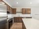 Bright kitchen featuring brown cabinets, stainless appliances, and an island with a white countertop at 5771 Freshwater Canyon Dr, St Cloud, FL 34771
