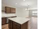 Open kitchen with brown cabinets, stainless steel appliances, and an island with white countertop at 5771 Freshwater Canyon Dr, St Cloud, FL 34771