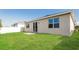 Well-maintained backyard with lush green lawn, patio, sliding glass doors, and view of adjacent homes at 606 Fairview Ave # 244, Haines City, FL 33844