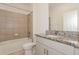 Bright bathroom featuring a tub-shower combo, tiled walls, granite countertop vanity, and modern fixtures at 606 Fairview Ave # 244, Haines City, FL 33844