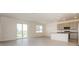 Open-concept living area with sliding glass doors, tile floors, and a modern kitchen area at 606 Fairview Ave # 244, Haines City, FL 33844