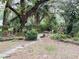 The backyard features a stone path, a small fountain, lush vegetation, and an outdoor seating area at 6116 Sweet Gum Run, Bartow, FL 33830