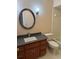 Bathroom vanity with dark countertop and a framed round mirror at 6116 Sweet Gum Run, Bartow, FL 33830