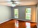 Bright bedroom with hardwood floors, ceiling fan, and two large windows at 6116 Sweet Gum Run, Bartow, FL 33830