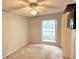 Comfortable bedroom features a ceiling fan, large window, closet, and modern television at 6116 Sweet Gum Run, Bartow, FL 33830