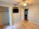 Comfortable bedroom with a ceiling fan, television, closet and view through the window at 6116 Sweet Gum Run, Bartow, FL 33830
