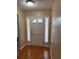Inviting entryway with hardwood floors, white door and sheer curtains at 6116 Sweet Gum Run, Bartow, FL 33830