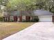 Beautiful brick home featuring a two-car garage, well-manicured landscaping, and an American flag at 6116 Sweet Gum Run, Bartow, FL 33830