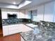 Kitchen featuring granite countertops, mosaic backsplash, stainless steel microwave and a deep basin sink at 6116 Sweet Gum Run, Bartow, FL 33830