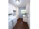 Laundry room featuring storage cabinets, a utility sink and tile flooring at 6116 Sweet Gum Run, Bartow, FL 33830