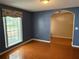 Living room featuring blue walls, hardwood floors, and large windows at 6116 Sweet Gum Run, Bartow, FL 33830