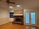 Cozy living room featuring a brick fireplace, built-in shelves, and French doors leading to the outside at 6116 Sweet Gum Run, Bartow, FL 33830