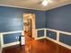 A living room featuring wainscotting, hardwood floors, and stainless steel refrigerator at 6116 Sweet Gum Run, Bartow, FL 33830