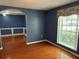 Living room featuring blue walls, hardwood floors, and a large window at 6116 Sweet Gum Run, Bartow, FL 33830