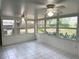 Enclosed porch with tile flooring, ceiling fans, and multiple windows to enjoy the scenery at 6116 Sweet Gum Run, Bartow, FL 33830