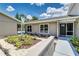 Inviting front exterior with manicured landscaping and walkway leading to a covered entrance and view of the pool at 6338 Oak E Sq, Lakeland, FL 33813