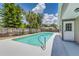 Inviting backyard pool with clear blue water, surrounded by lush greenery and a privacy fence at 6338 Oak E Sq, Lakeland, FL 33813