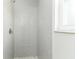 A walk-in shower has gray subway tiles, a shower head and a small window at 6338 Oak E Sq, Lakeland, FL 33813
