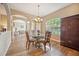 Open dining area featuring a chandelier, round glass table, and wood-look flooring at 6339 Alamanda Hills Dr, Lakeland, FL 33813