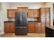A modern black refrigerator is set against wood cabinetry and countertops at 6339 Alamanda Hills Dr, Lakeland, FL 33813