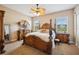 Ornate primary bedroom featuring a canopy bed, ceiling fan, and neutral colors at 6339 Alamanda Hills Dr, Lakeland, FL 33813