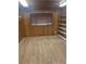 Bedroom featuring wood paneling, built-in shelves, and wood-look flooring at 6632 Sweetbriar Ln, Lakeland, FL 33813