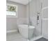 Modern bathroom features a soaking tub, glass shower, and large window at 727 S Missouri Ave, Lakeland, FL 33815