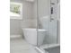 Modern bathroom features a soaking tub, glass shower, and large window at 727 S Missouri Ave, Lakeland, FL 33815