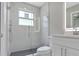 Modern bathroom features a glass shower, window, light gray tile, and white vanity at 727 S Missouri Ave, Lakeland, FL 33815