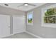 Bedroom with ceiling fan, two windows looking out to greenery, and a closet at 727 S Missouri Ave, Lakeland, FL 33815