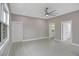 A bright bedroom with a ceiling fan, three doors, and light gray walls and floor at 727 S Missouri Ave, Lakeland, FL 33815