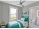 Bright bedroom features a ceiling fan, large window, aqua accents, and an ensuite bathroom at 727 S Missouri Ave, Lakeland, FL 33815