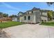 View of two homes showcasing driveways, well-kept lawns, and recently installed exteriors at 731 S Missouri Ave, Lakeland, FL 33815