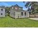 Spacious backyard with green grass and mature trees showing the home's rear exterior at 731 S Missouri Ave, Lakeland, FL 33815