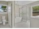 This bathroom features a standalone tub, a glass-enclosed shower, and two windows for plenty of natural light at 731 S Missouri Ave, Lakeland, FL 33815