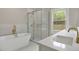 Modern bathroom with a walk-in shower, soaking tub, and double vanity sinks with gold fixtures at 731 S Missouri Ave, Lakeland, FL 33815