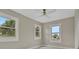 Bright bedroom featuring three windows, neutral paint, white trim, and light gray wood floors at 731 S Missouri Ave, Lakeland, FL 33815
