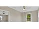 A bright bedroom with two windows, a ceiling fan, and an open doorway into another room at 731 S Missouri Ave, Lakeland, FL 33815