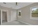 Cozy bedroom with a ceiling fan, two windows, a closet with bi-fold doors, and an ensuite bathroom at 731 S Missouri Ave, Lakeland, FL 33815