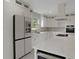Well-lit kitchen showcasing stainless steel appliances, white cabinets, a large island, and modern fixtures at 731 S Missouri Ave, Lakeland, FL 33815