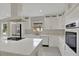 Beautiful white kitchen with stainless steel appliances, a large island, and modern fixtures at 731 S Missouri Ave, Lakeland, FL 33815