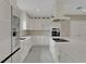 Spacious kitchen with white cabinets, a large center island with a cooktop, and stainless steel appliances at 731 S Missouri Ave, Lakeland, FL 33815