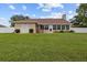 A well-maintained backyard features a large lawn, white fence, and an enclosed lanai at 7932 Ridge Pointe W Dr, Lakeland, FL 33810