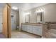 Bright bathroom featuring double vanities, granite counters, tile floors, and separate tub at 7932 Ridge Pointe W Dr, Lakeland, FL 33810