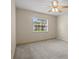 Bedroom featuring neutral paint, neutral carpet, ceiling fan, and large window at 7932 Ridge Pointe W Dr, Lakeland, FL 33810