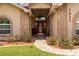 Charming home entrance with brick accents, arched window, and walkway with manicured landscaping at 7932 Ridge Pointe W Dr, Lakeland, FL 33810